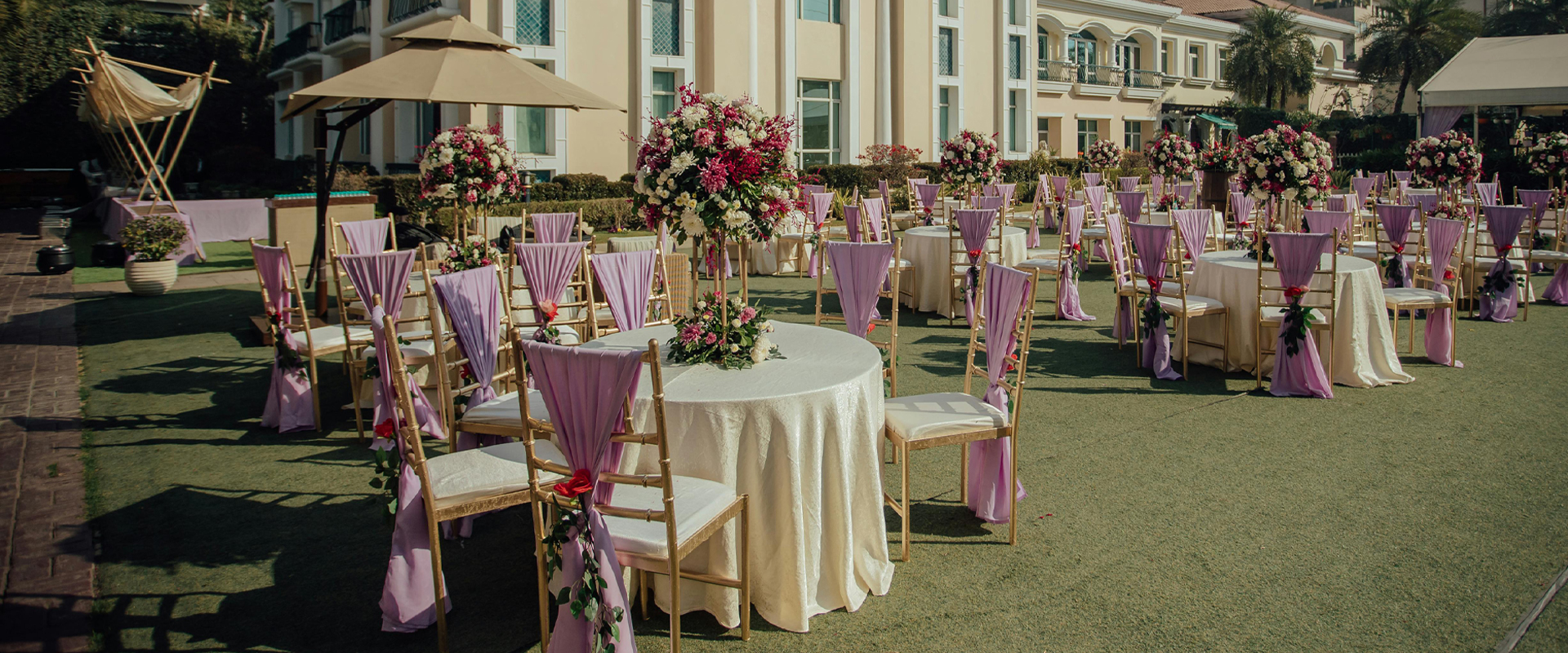 Image of a wedding tent rental set up, featuring a large white tent with string lights, tables and chairs, and elegant floral arrangements